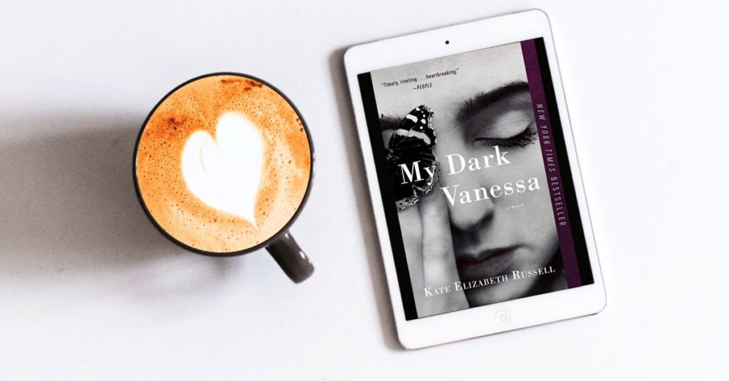 Coffee cup alongside an eReader showing the cover of My Dark Vanessa