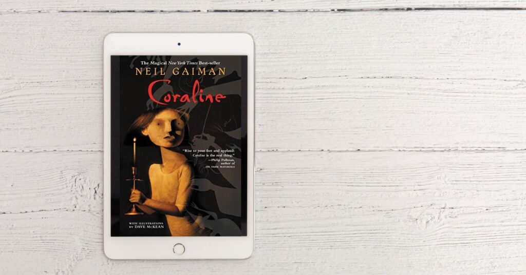 eReader on amid a white wood backdrop showing the cover of Coraline