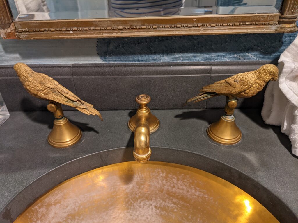 The handles of the sink are gold birds