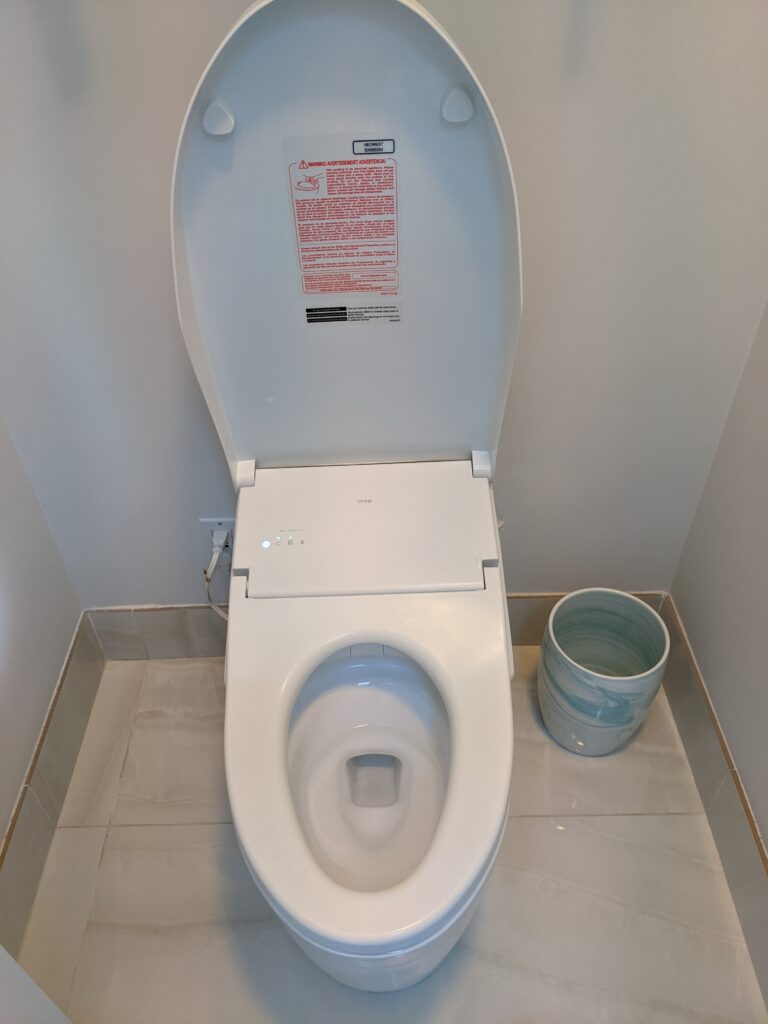 A Toto toilet with the lid up