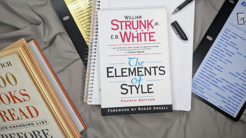 The book, "The Elements of Style" atop a notebook with an uncapped pen