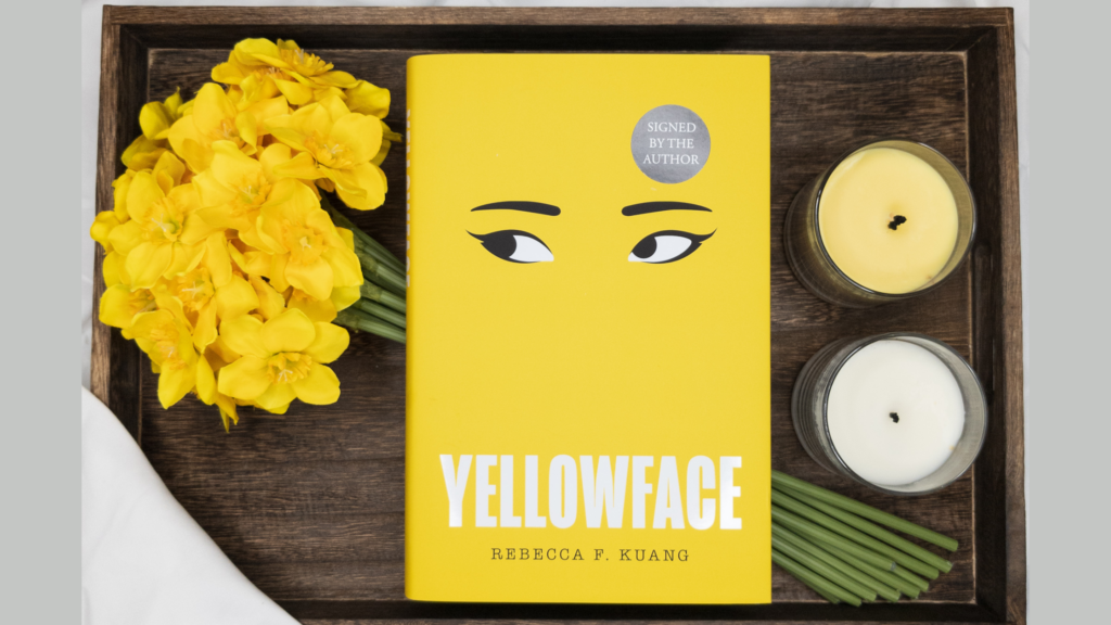 Tray with daffodils and a yellow and white candle with a copy of Yellowface over the flowers